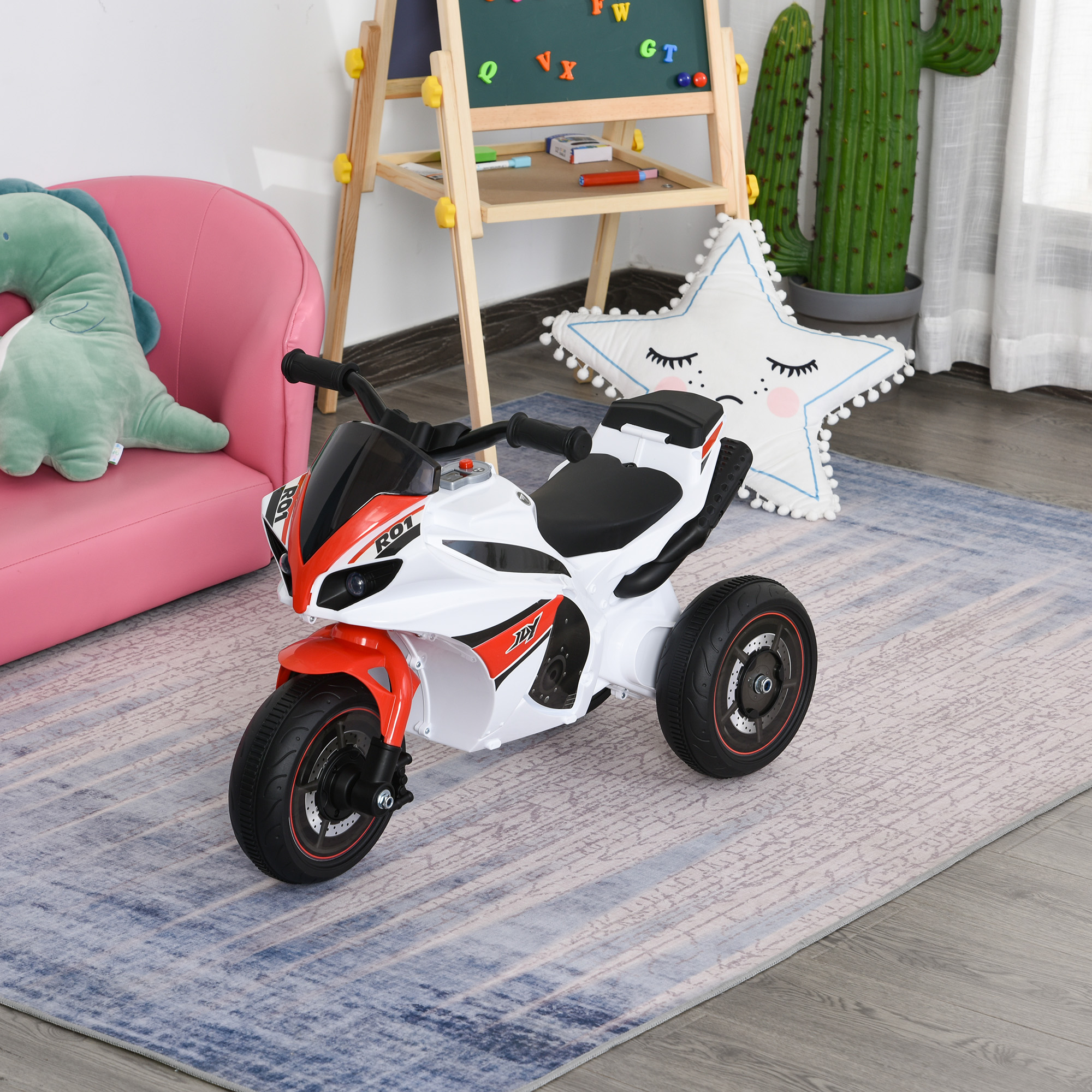 Una moto giocattolo triciclo bianca e rossa è posizionata su un tappeto in una stanza per bambini.