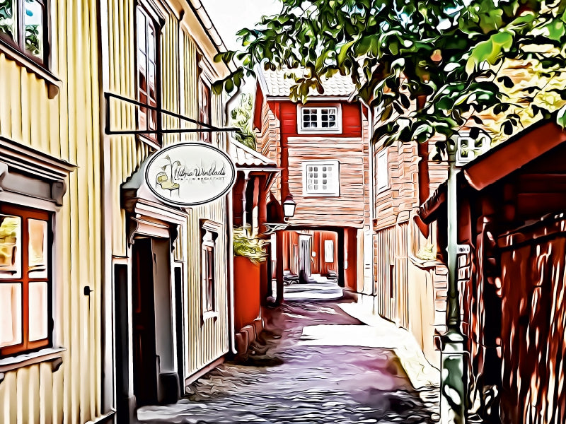 Eine malerische Gasse mit gelben und roten Holzhäusern, einem Schild und Bäumen im Hintergrund.