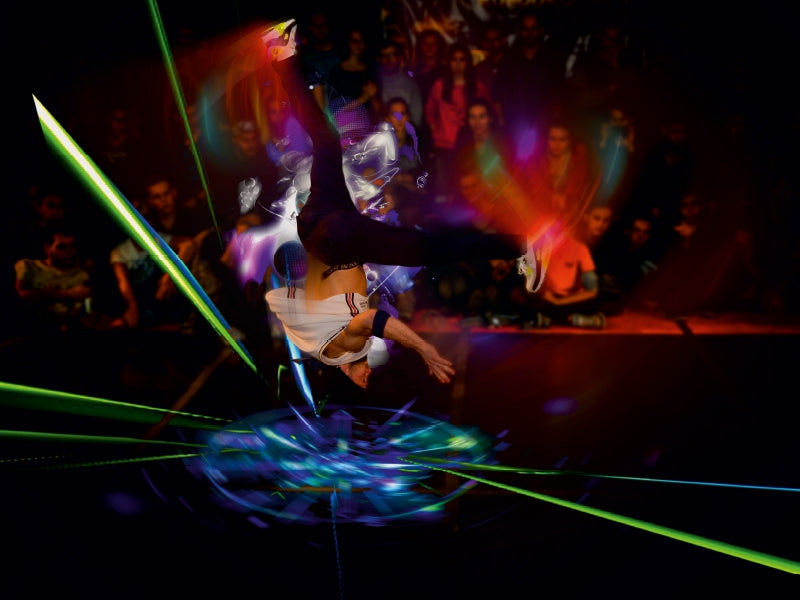 Ein Breakdancer macht einen Kopfstand mit digitalen Lichteffekten vor einer Zuschauermenge.