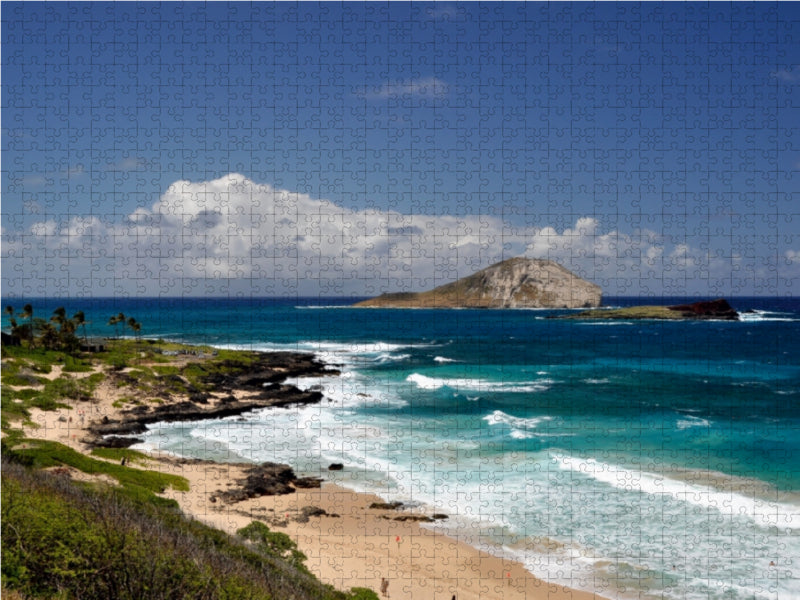 Ein Puzzle zeigt eine tropische Kueste mit türkisblauem Meer, Felsen und einer Insel im Hintergrund.