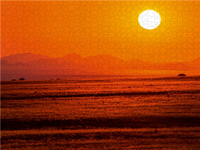 Ein leuchtender Sonnenuntergang über einer weiten Savanne, bedeckt mit einem Puzzle-Muster.