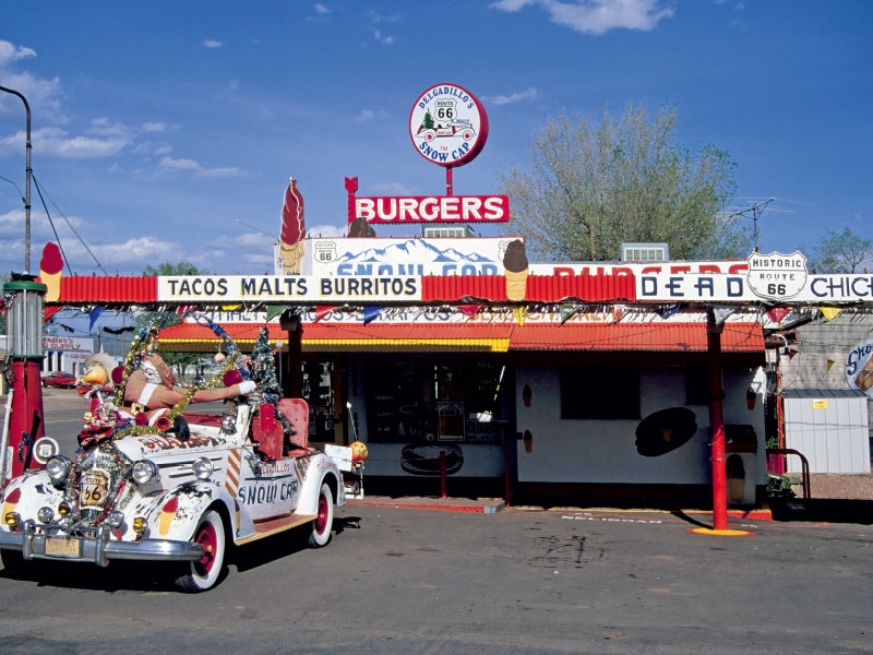 Das Delgadillo's Snow Cap Restaurant an der Route 66 mit einem dekorierten Oldtimer davor.
