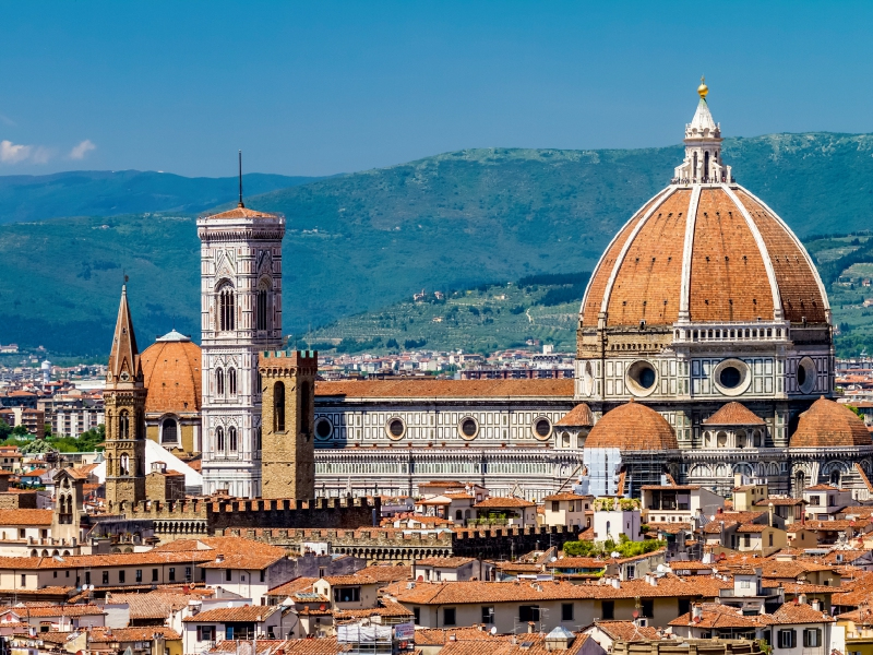 Blick auf die Kathedrale von Florenz mit ihrer großen Kuppel, dem Glockenturm und den roten Dächern der Stadt.