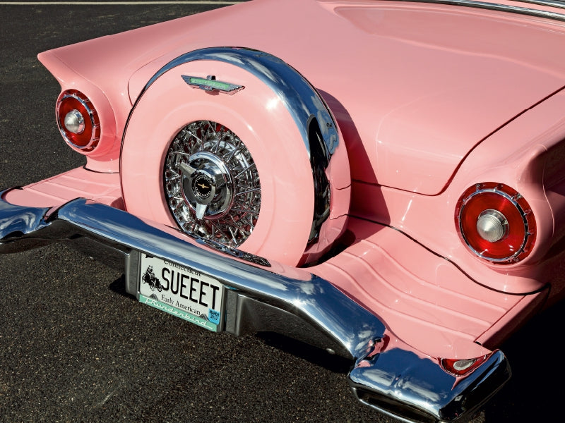 Rückansicht eines rosa Vintage-Autos mit Chromakzenten und dem Nummernschild SUEEET.