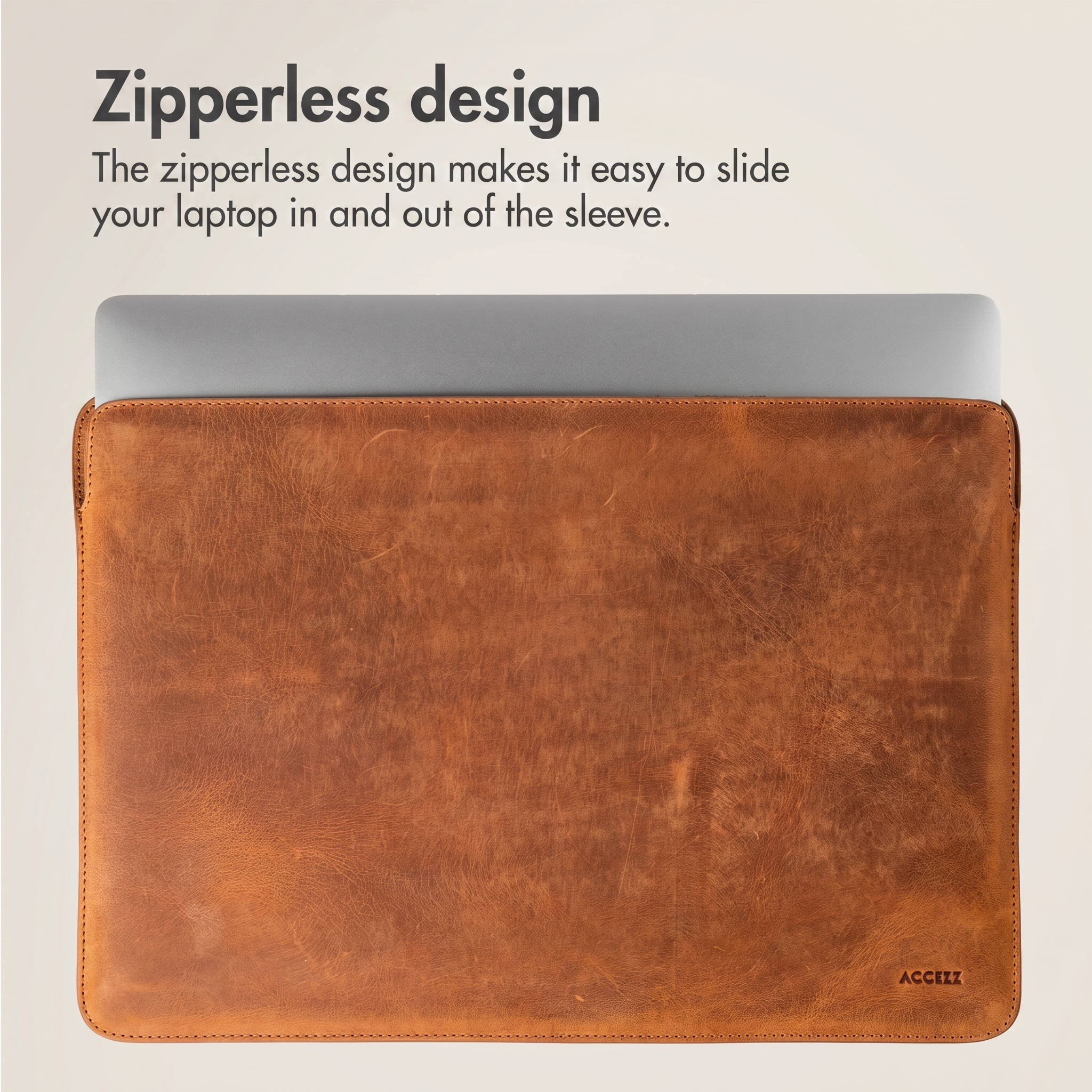 Una laptop plateada está dentro de una funda de cuero marrón con texto arriba.