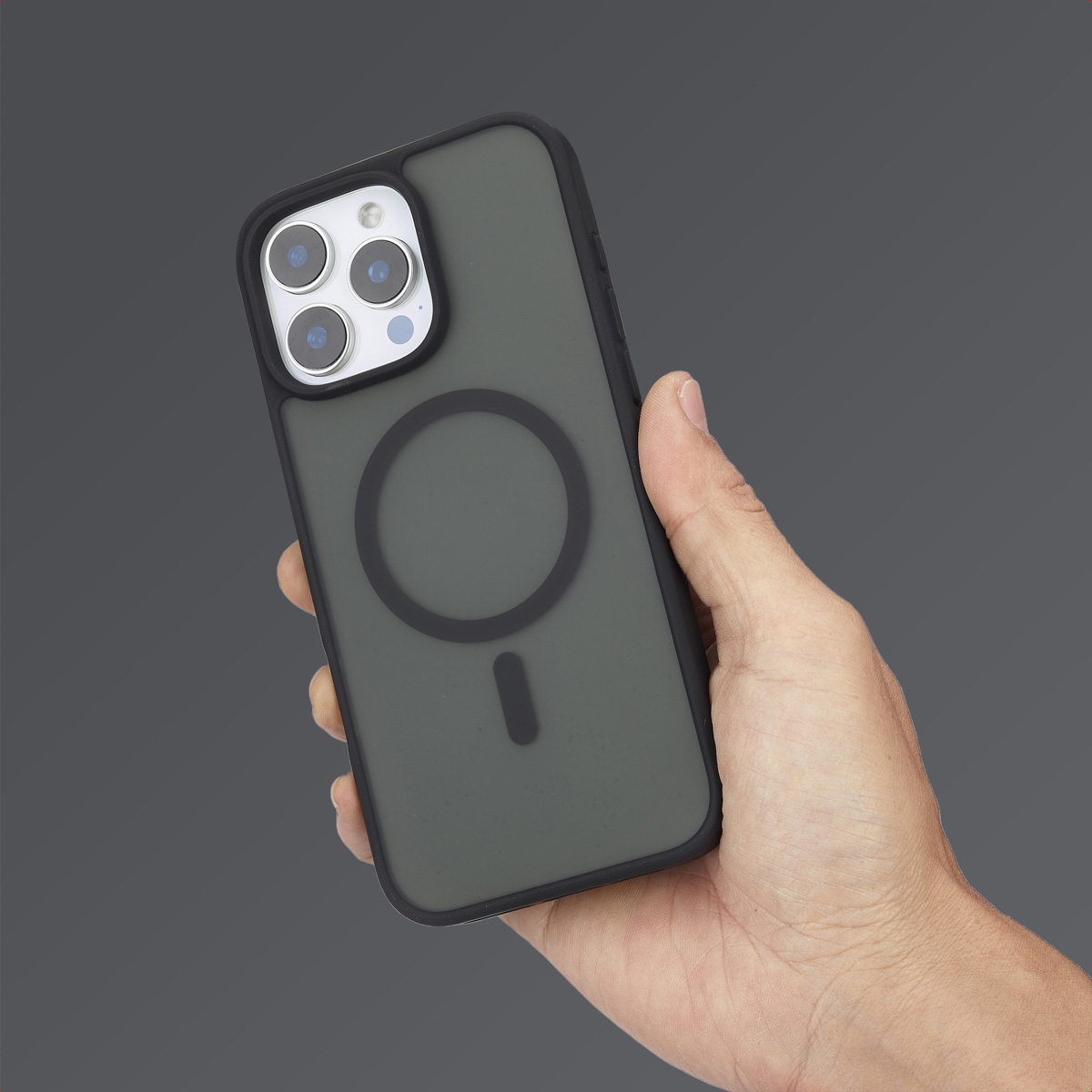 Una mano sostiene un smartphone verde en una funda protectora con marca MagSafe circular.