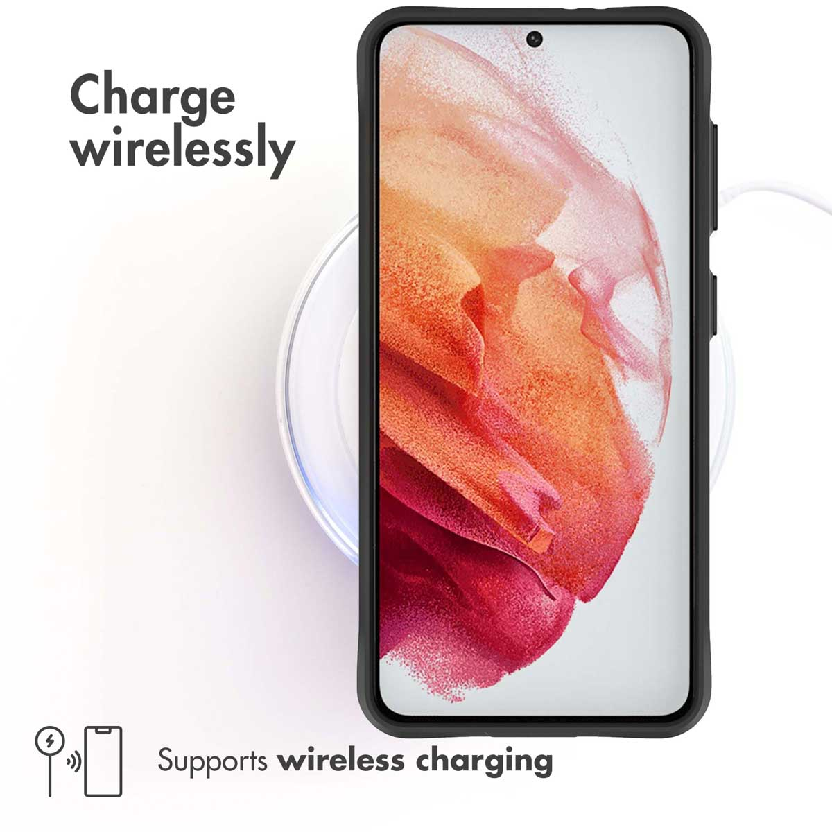 Un smartphone descansa en una base de carga inalámbrica redonda con el texto "Charge wirelessly".