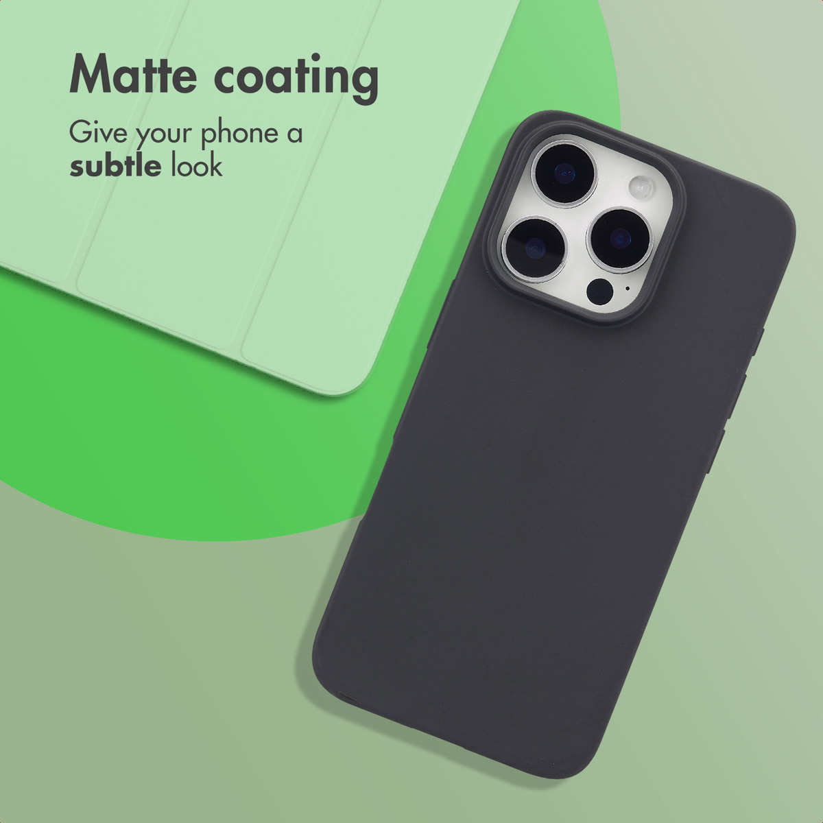 Un smartphone dans une coque noire mate repose sur un fond vert à côté d'une housse assortie.