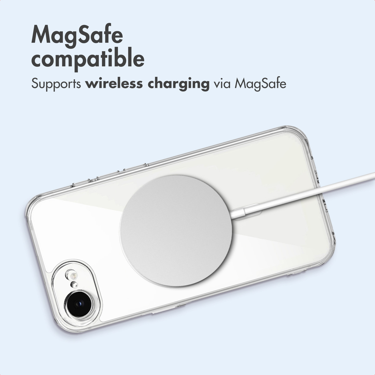 Un teléfono en una funda transparente cargando de forma inalámbrica con MagSafe sobre fondo azul claro.