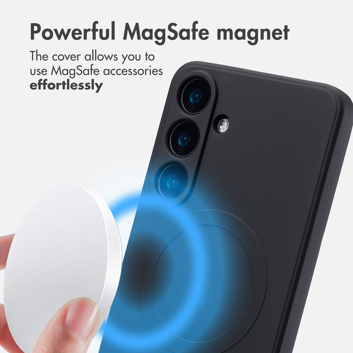 Ręka trzyma okrągły biały magnes w pobliżu czarnego etui na telefon z wbudowanym pierścieniem MagSafe.