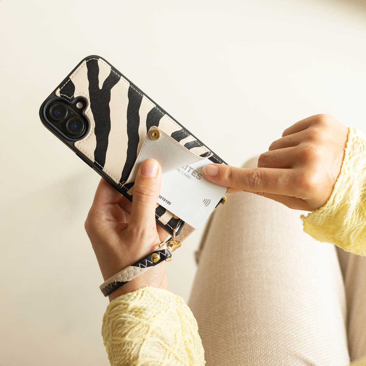 Personne tenant une coque de téléphone à motif zèbre avec poche pour carte.