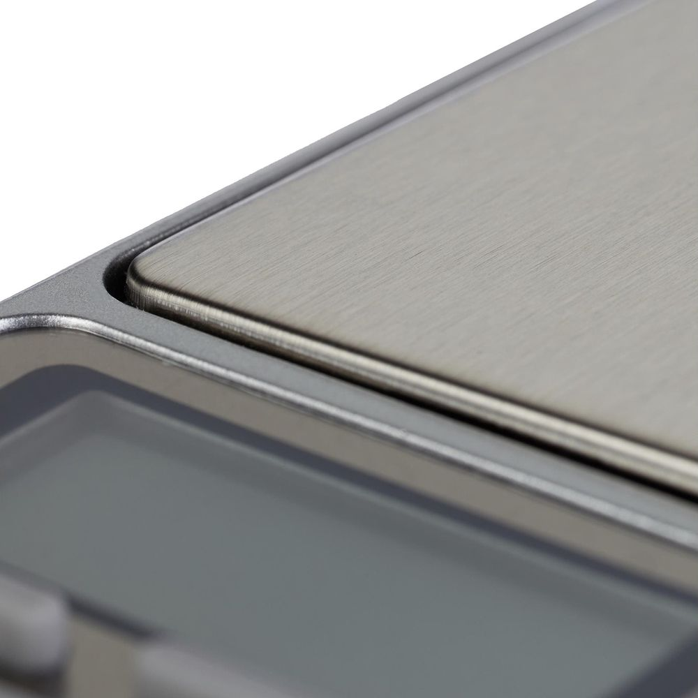 Nahaufnahme einer Metallwaage mit digitalem Display und gebürsteter Oberfläche.