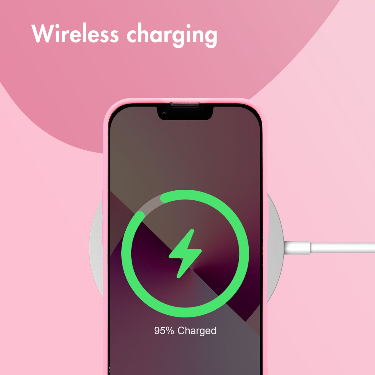 Smartfon ładuje się bezprzewodowo na podkładce, wyświetlając komunikat 95% Charged na różowym tle.