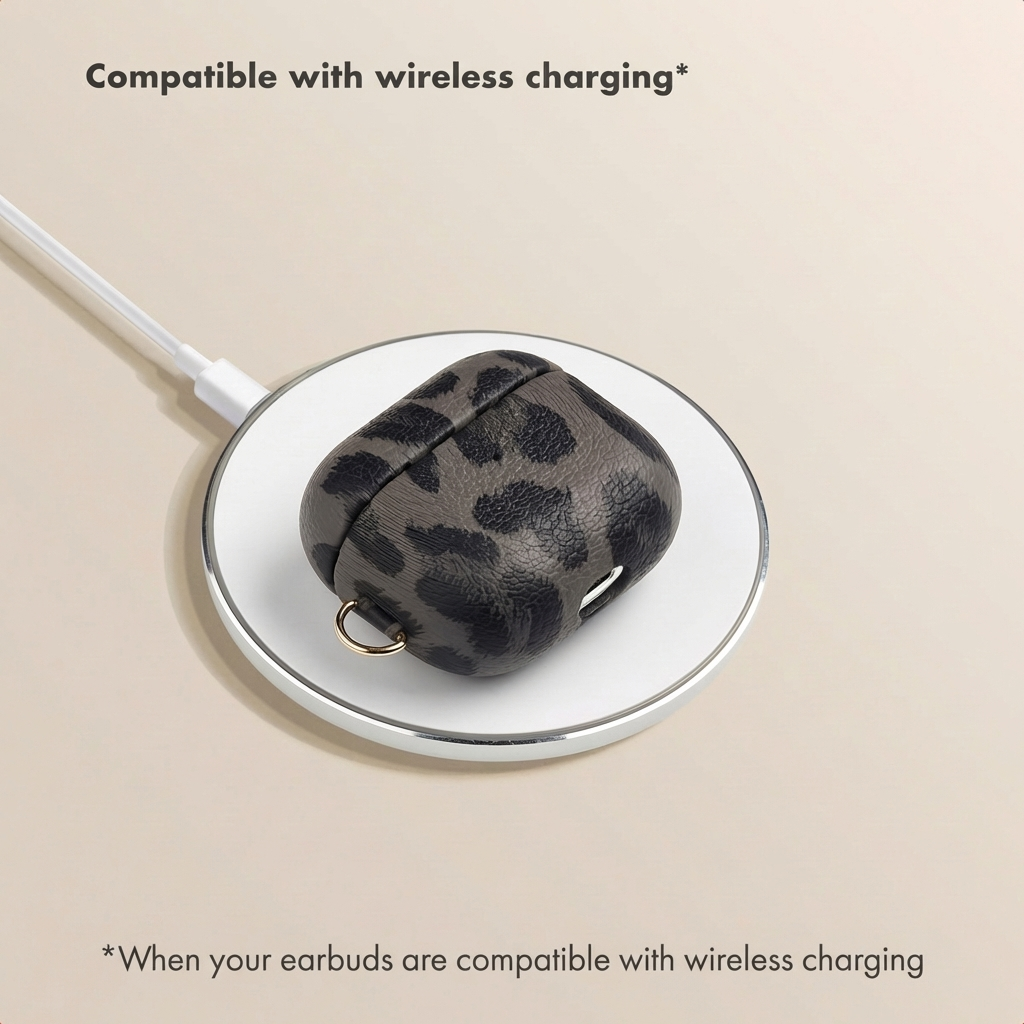 Un estuche de AirPods gris con estampado de leopardo descansa sobre una base de carga inalámbrica blanca.