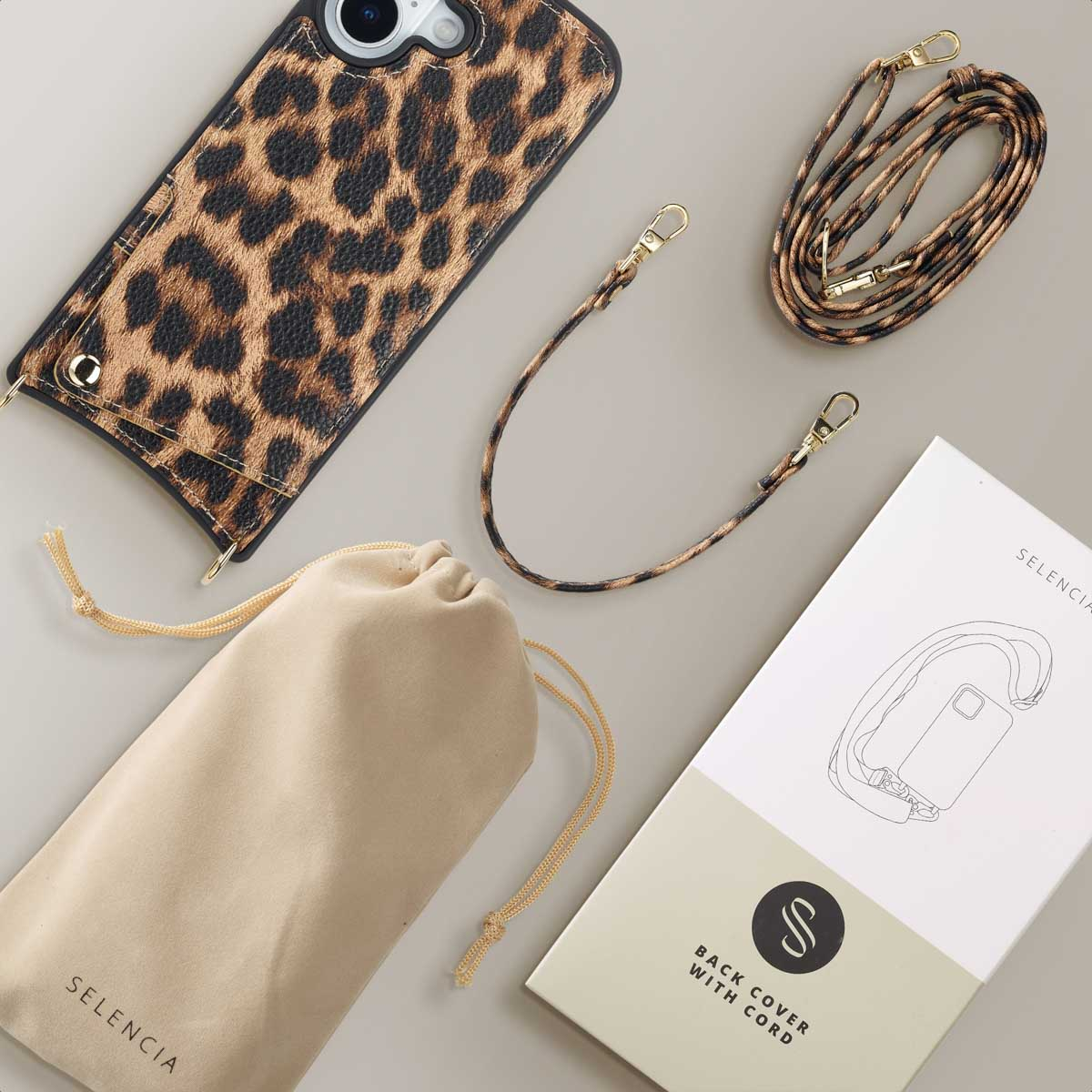 Funda de móvil con estampado de leopardo, dos correas, bolsa y caja sobre fondo gris.