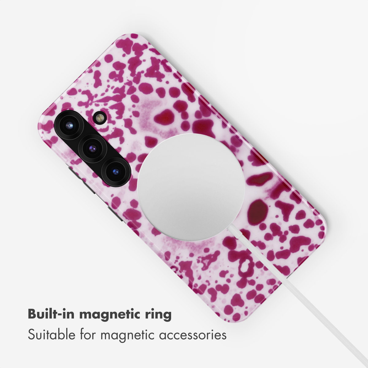 Una funda para teléfono con manchas de tinta magenta y un anillo magnético.