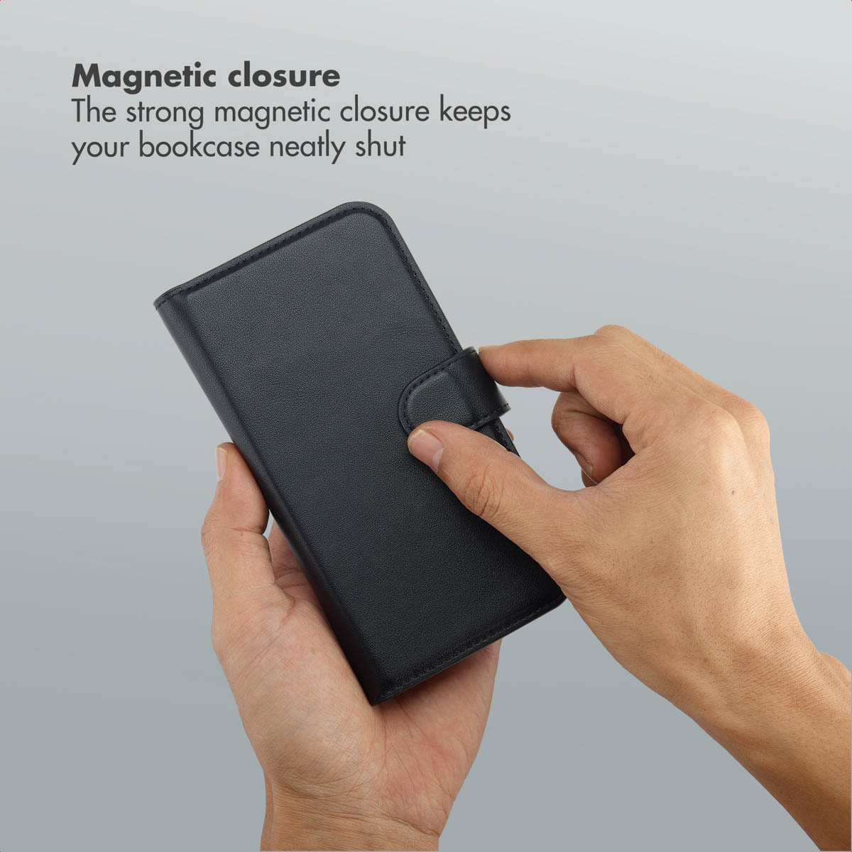 Mani che tengono una custodia in pelle nera chiusa da una chiusura magnetica.