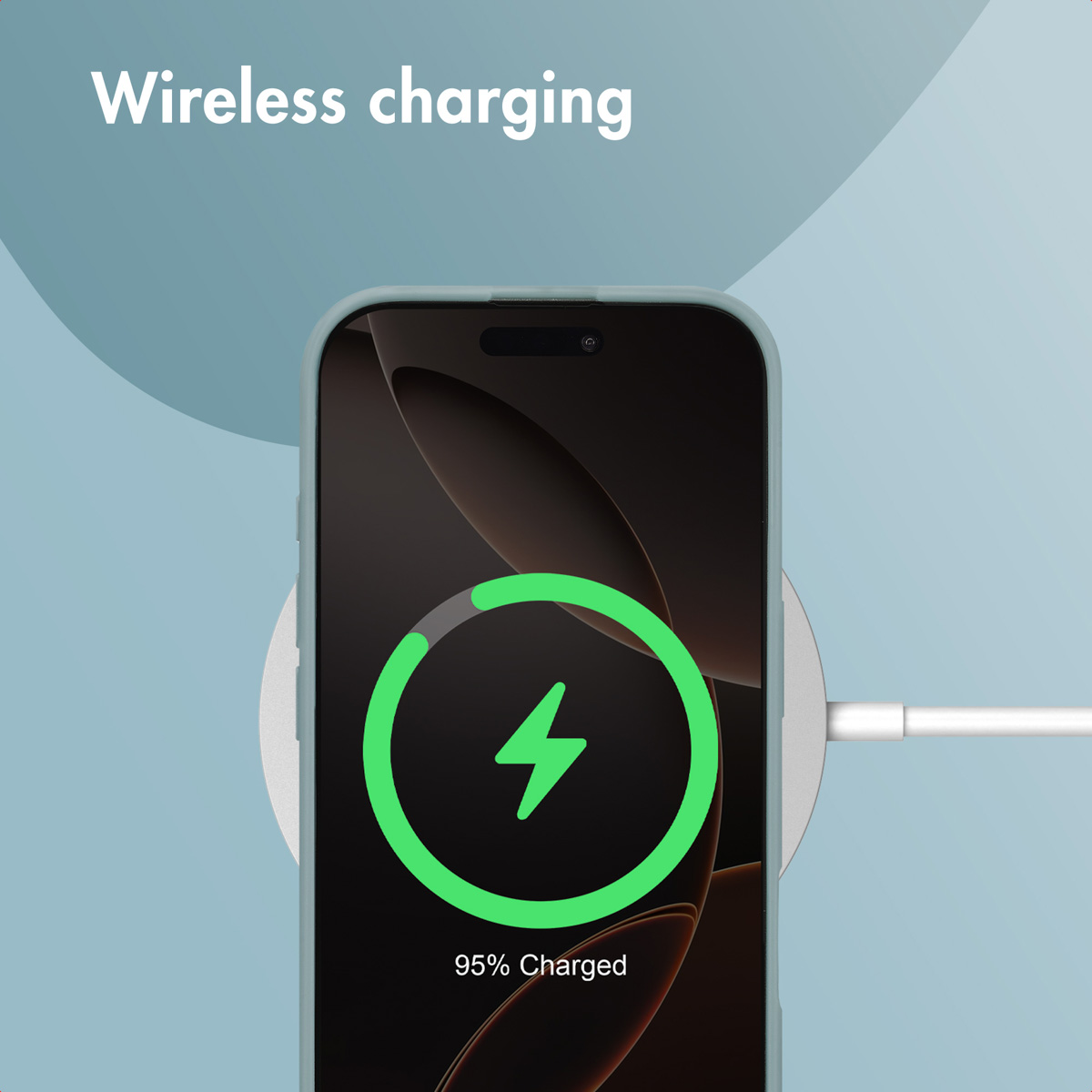 Un smartphone gris se recharge sans fil sur un socle rond sur fond bleu.