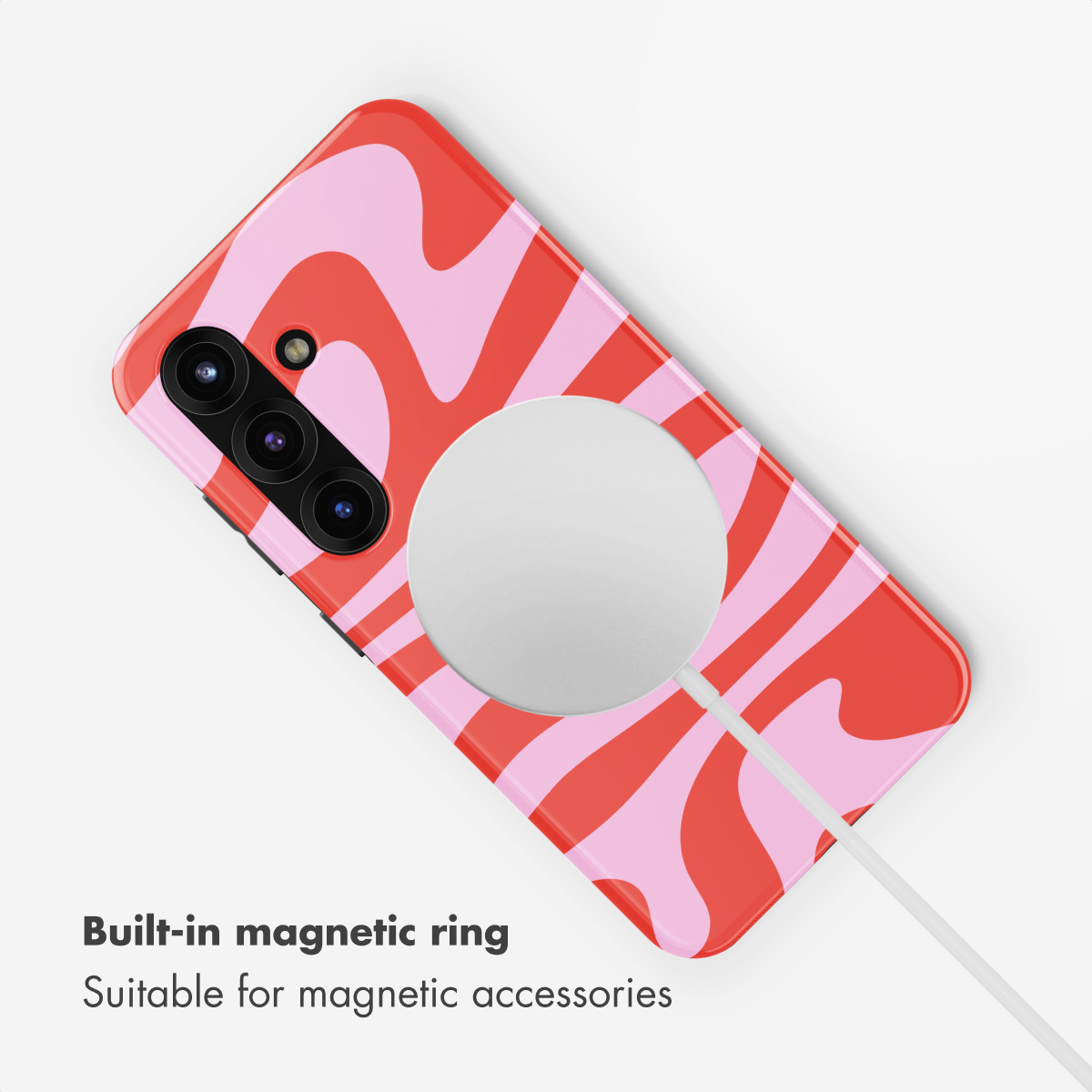 Una funda de móvil con rayas onduladas rojas y rosas y un cargador magnético circular.