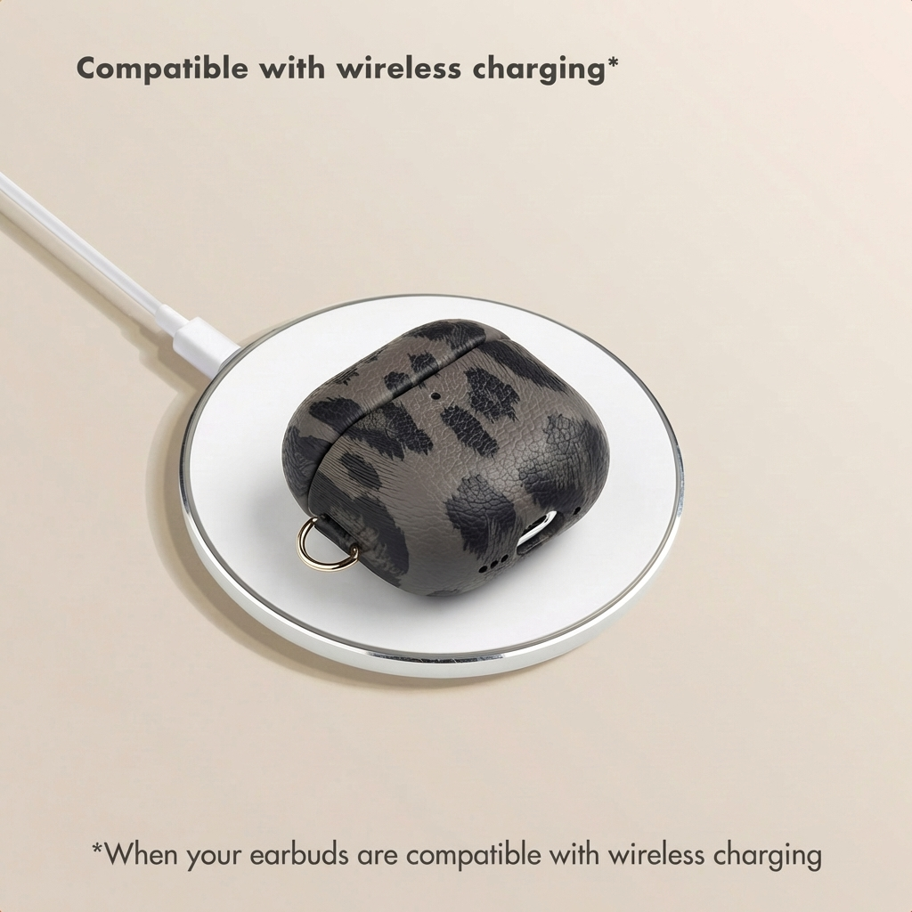 Una custodia grigia per AirPods con stampa leopardata si trova su una base di ricarica wireless bianca con cavo.