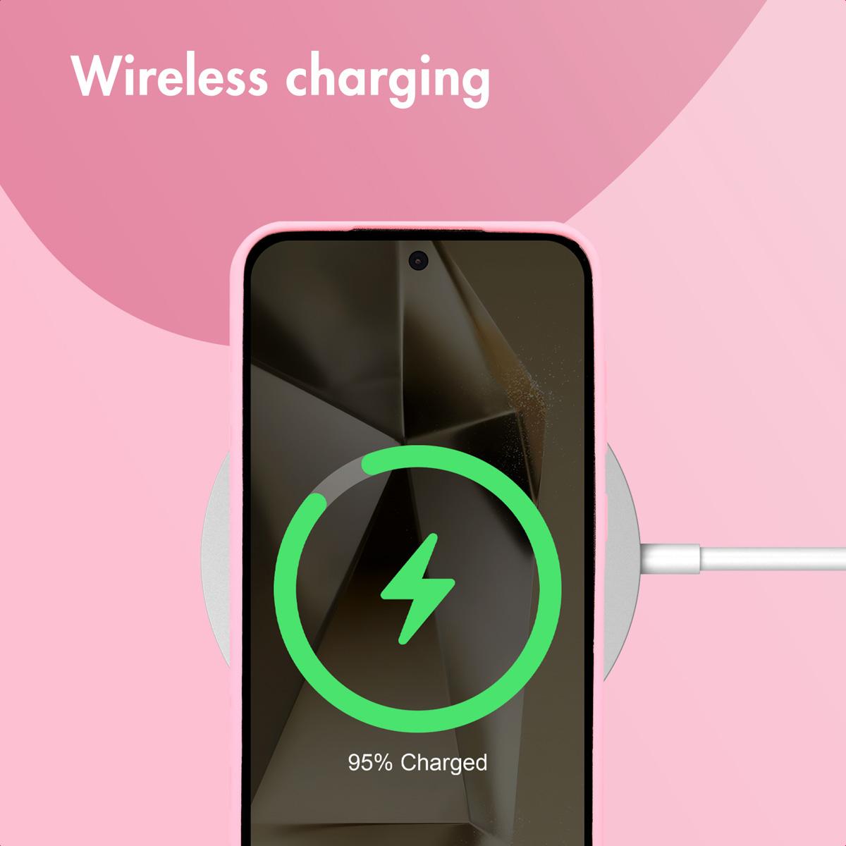 Smartfon na bezprzewodowej ładowarce na różowym tle, wskazujący 95% naładowania.