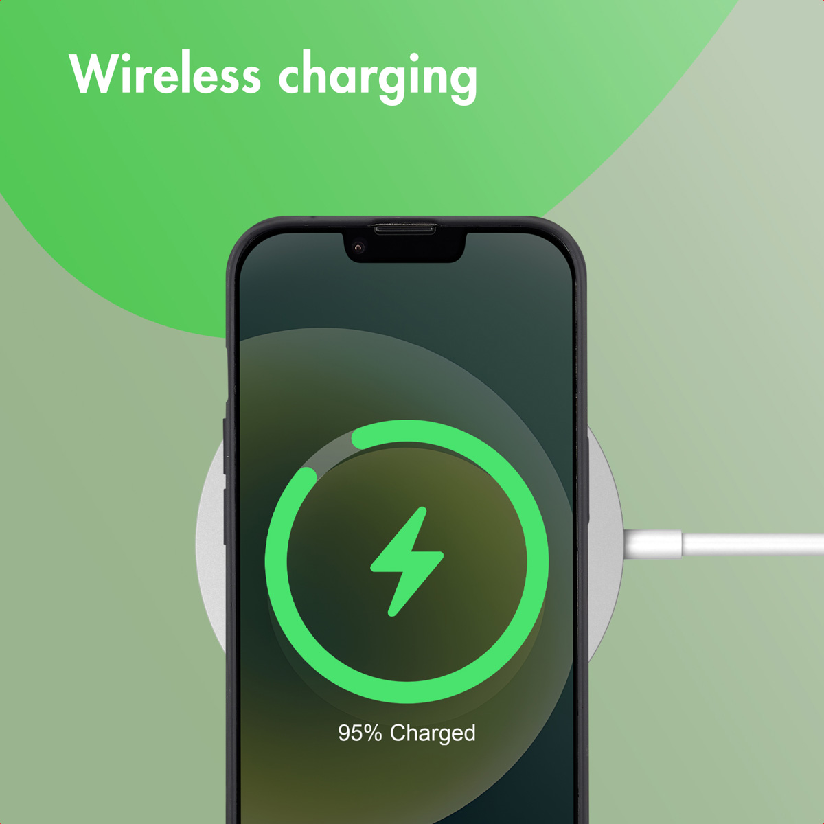 Uno smartphone si ricarica in modalità wireless su un pad su sfondo verde.