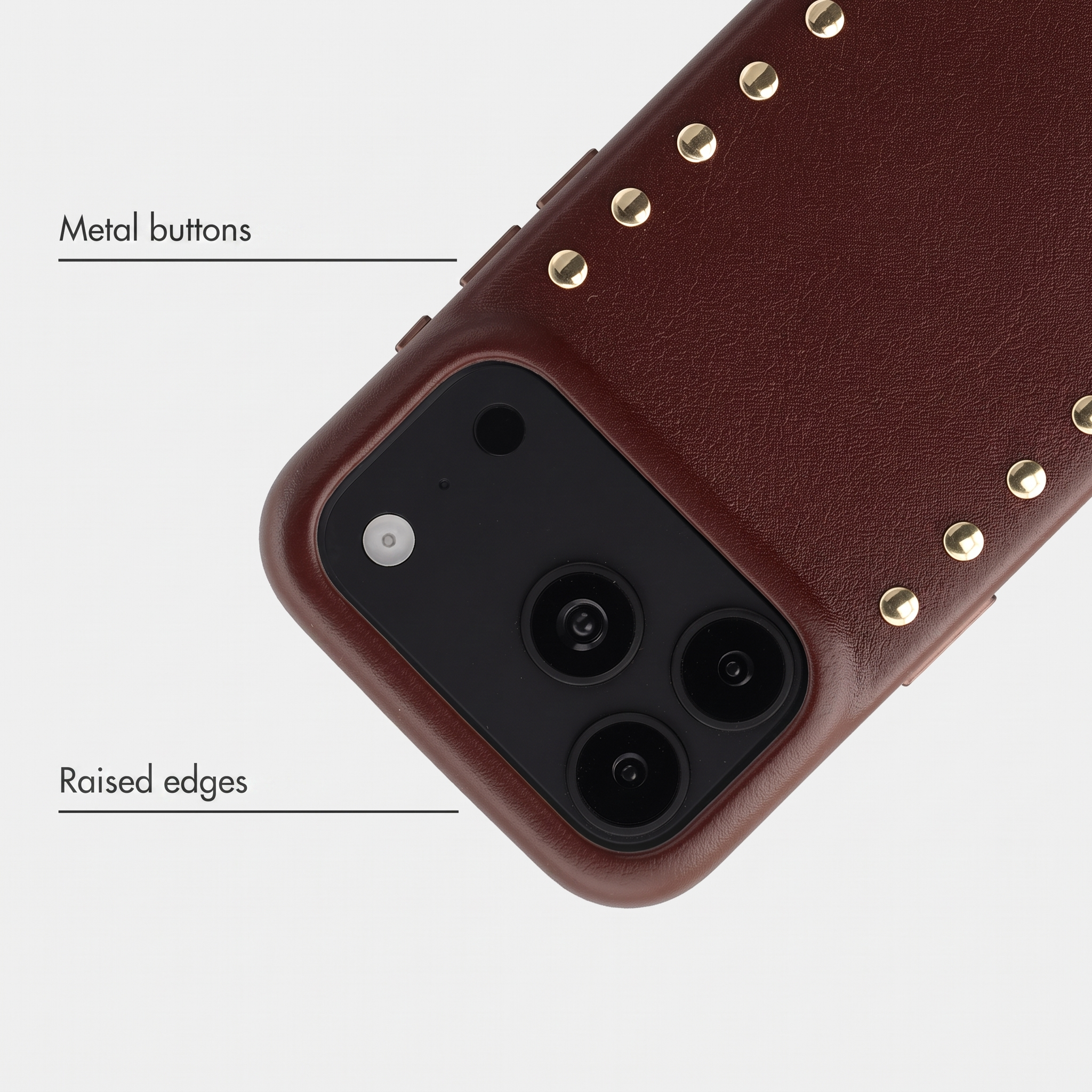 Coque de téléphone en cuir marron avec clous dorés, boutons en métal et bords surélevés.
