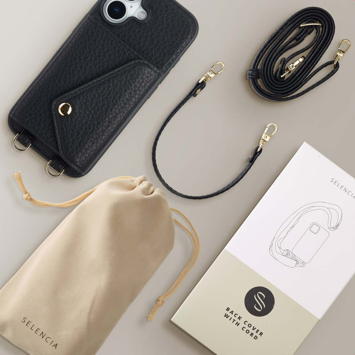 Une coque noire, des lanières, une pochette beige et une boîte Selencia sur fond clair.