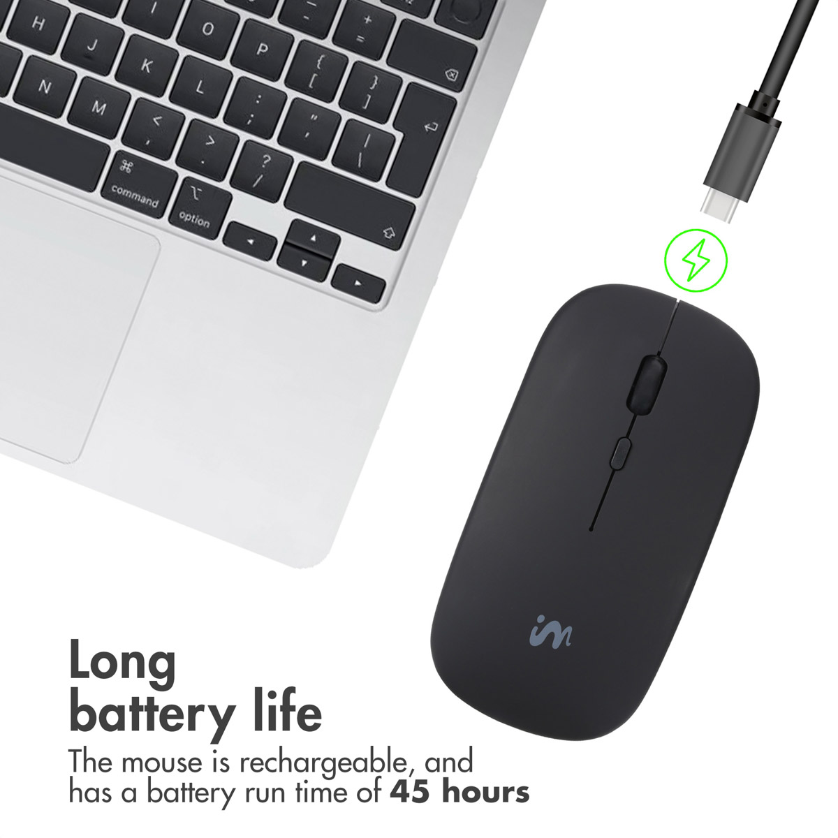 Eine schwarze kabellose Maus neben einem Laptop, ein USB-C-Kabel zum Laden bereit.