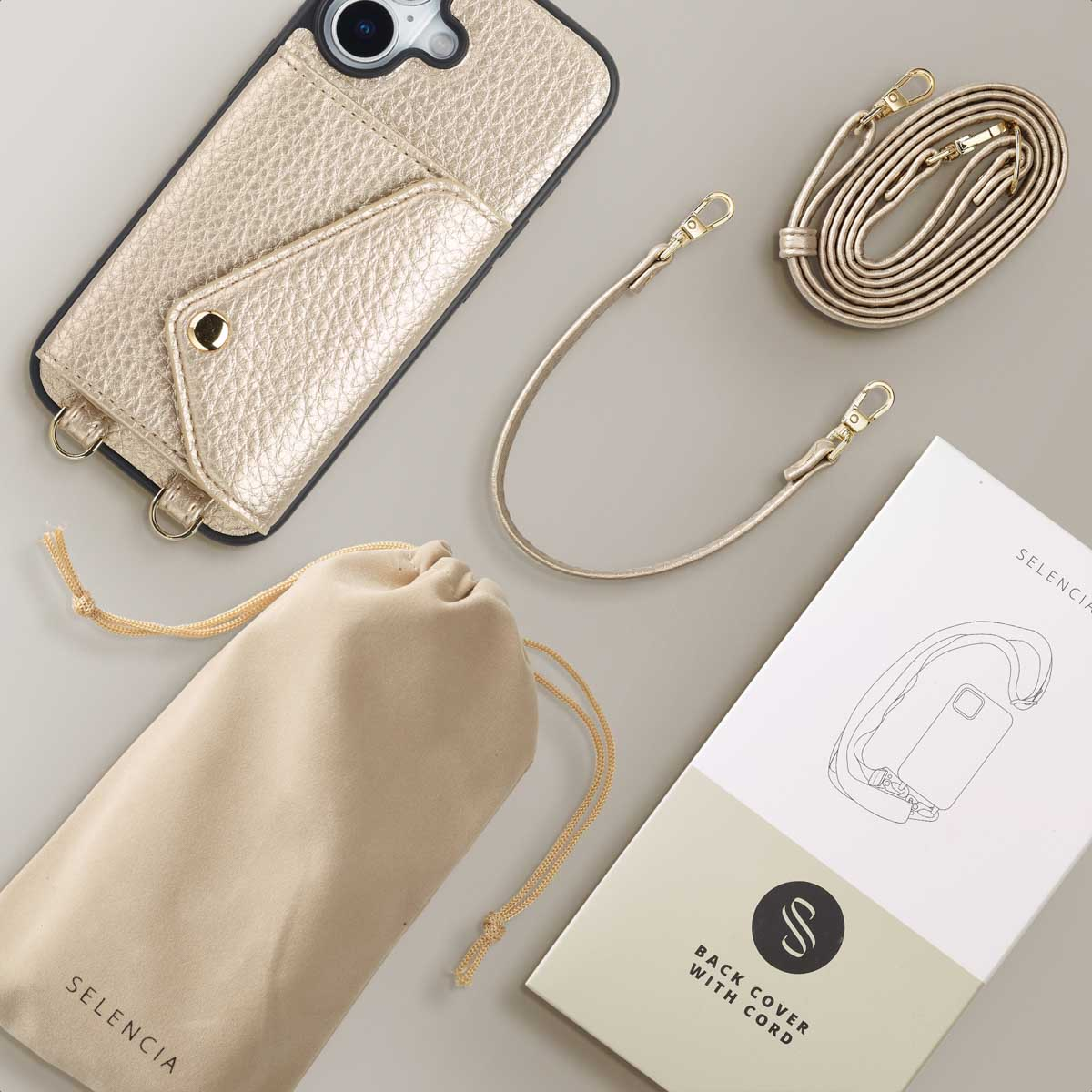 Coque de téléphone dorée avec poche, deux lanières, pochette et emballage.