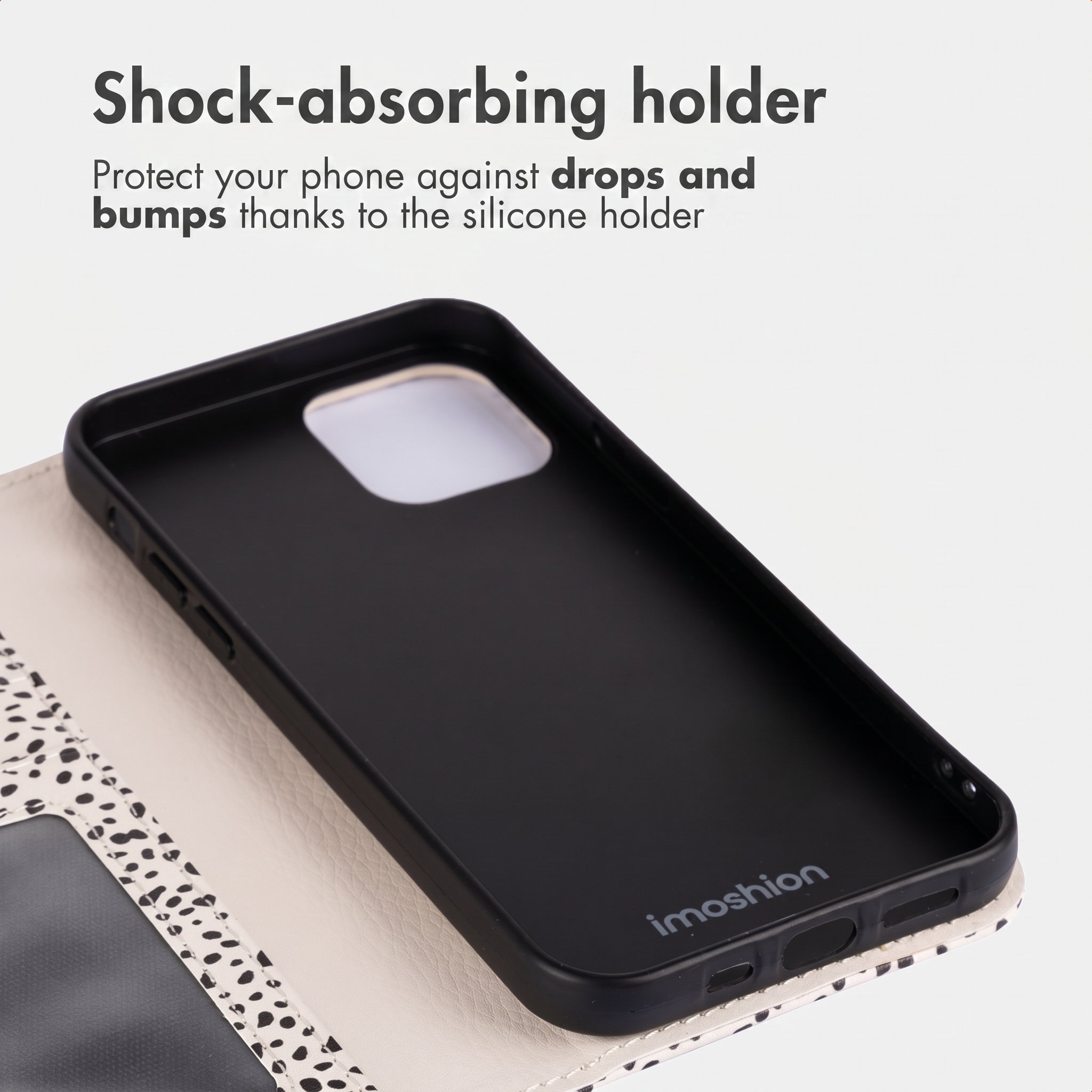 Une coque de téléphone en silicone noire absorbant les chocs dans un étui blanc à motifs, avec du texte au-dessus.