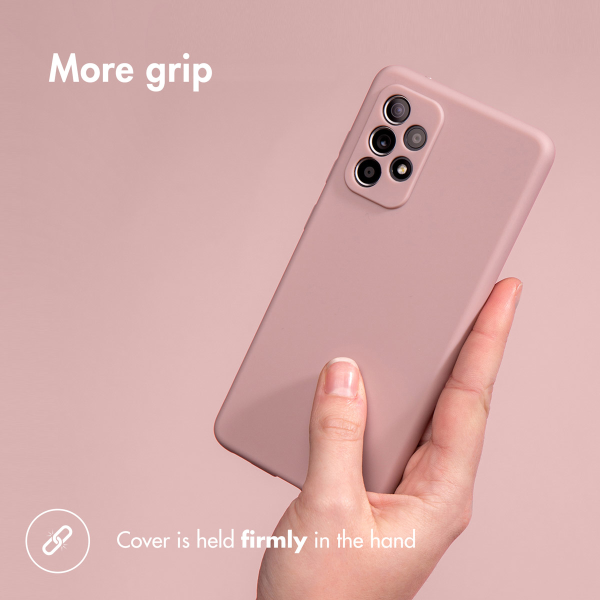 Une main tient fermement un smartphone rose avec une coque de protection sur fond rose.