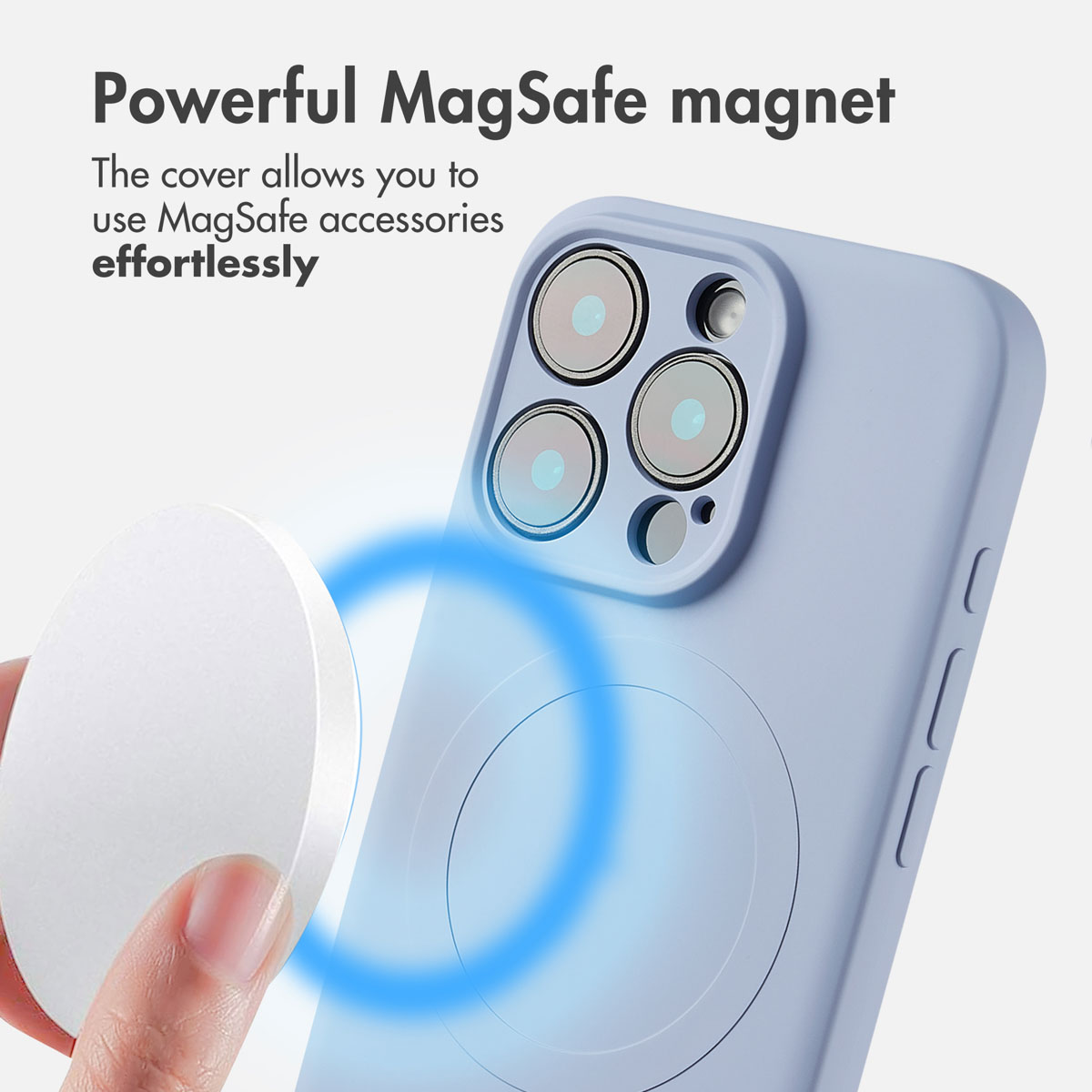 Una mano tiene un caricabatterie MagSafe bianco vicino al retro di una custodia azzurra con anello magnetico.