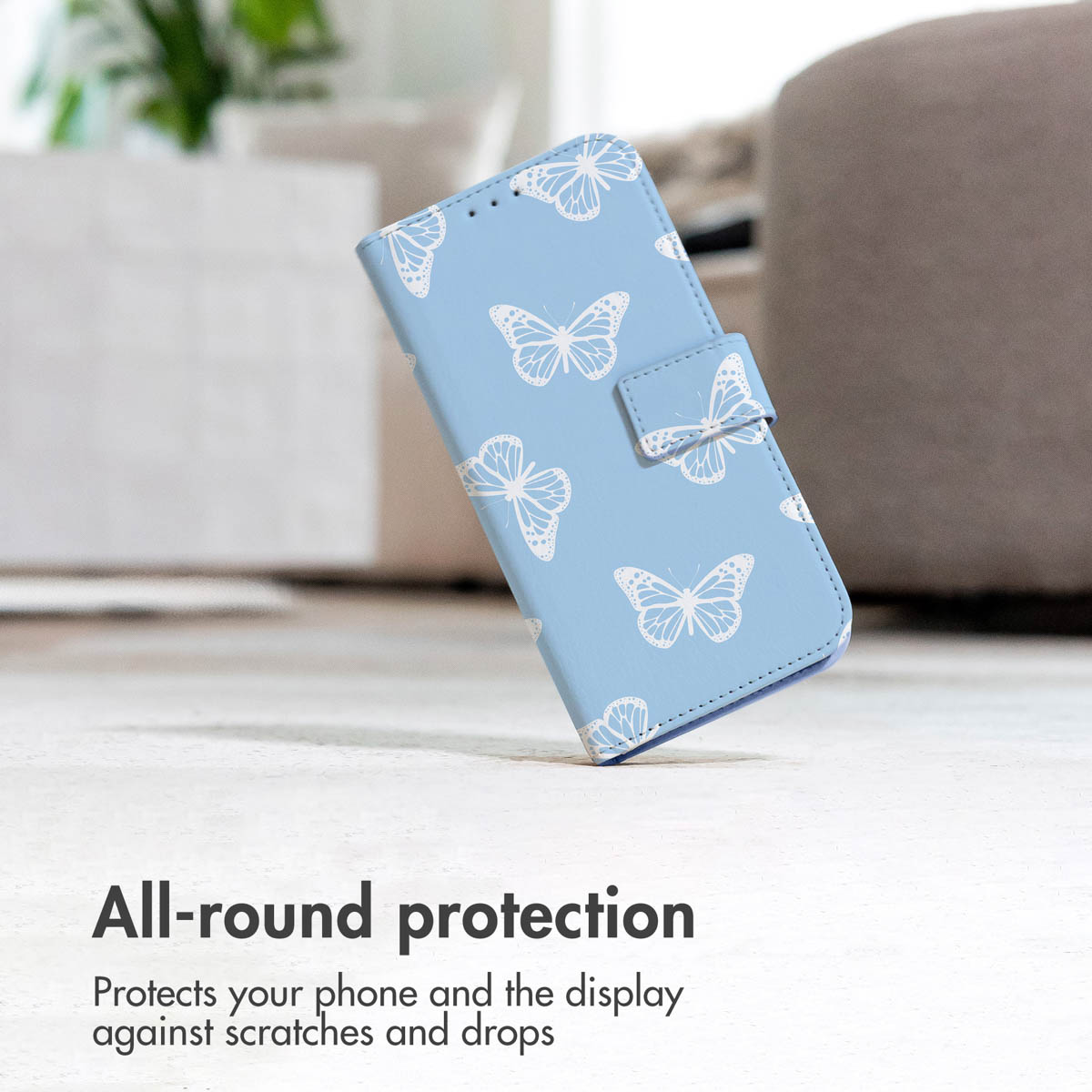 Un étui de téléphone bleu clair avec des papillons blancs, debout sur une surface blanche.