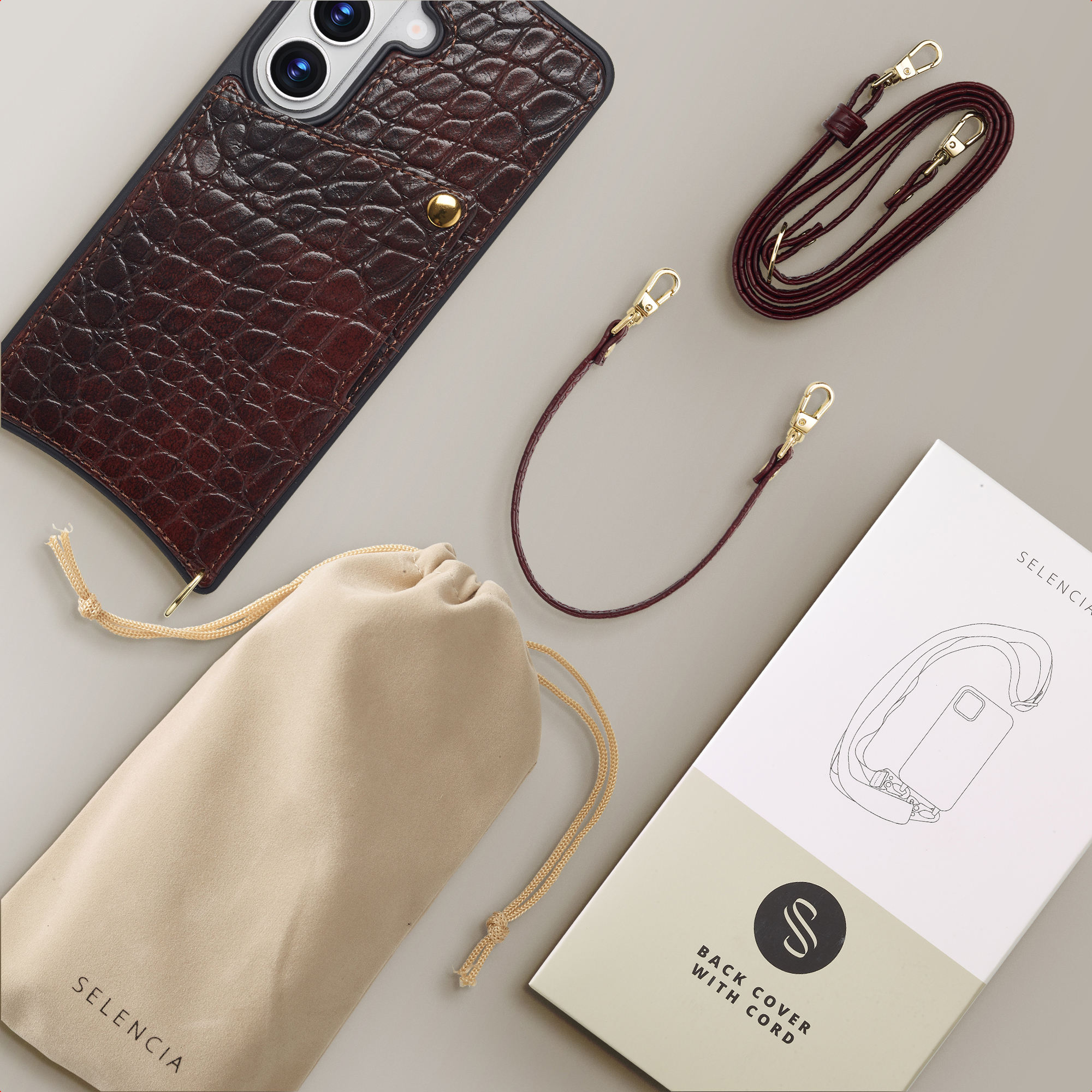 Funda de teléfono de cocodrilo marrón oscuro con bolsillo, correas, bolsa y caja.
