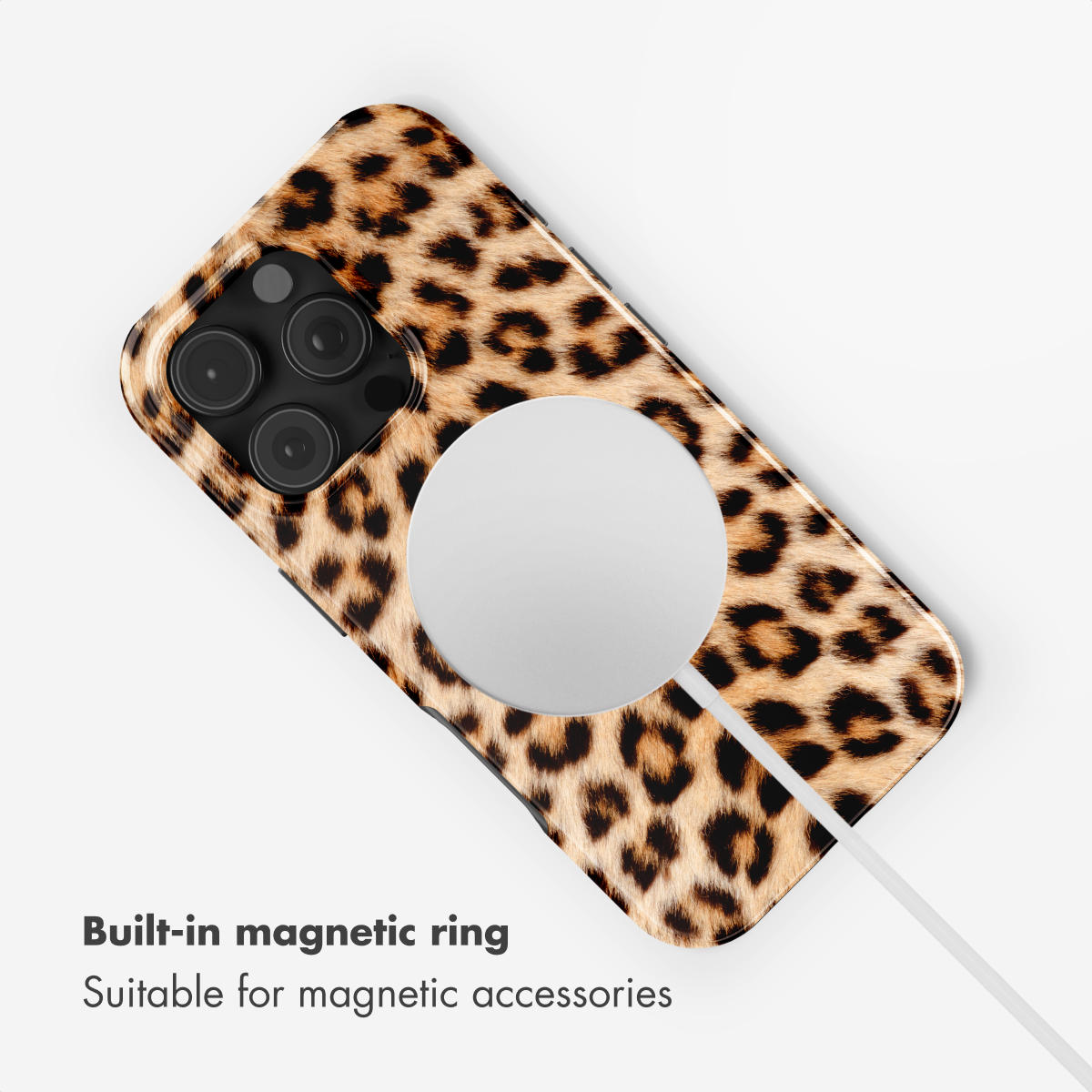 Uno smartphone con custodia leopardata e anello magnetico bianco integrato sul retro, collegato a un cavo bianco.