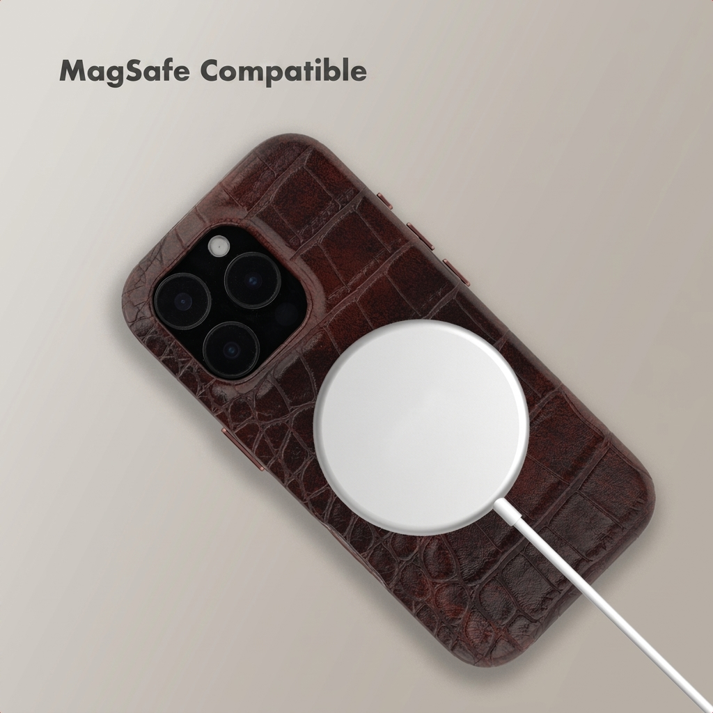 A brown crocodile-textured leather phone case lies on a light background with a white MagSafe charger.