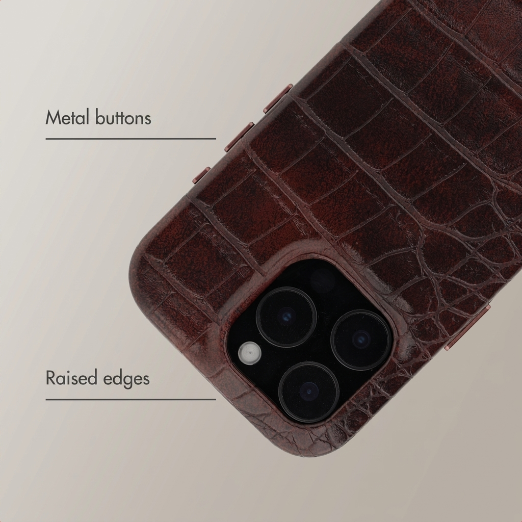 Brown crocodile leather phone case with metal buttons and raised edges around the triple-lens camera.