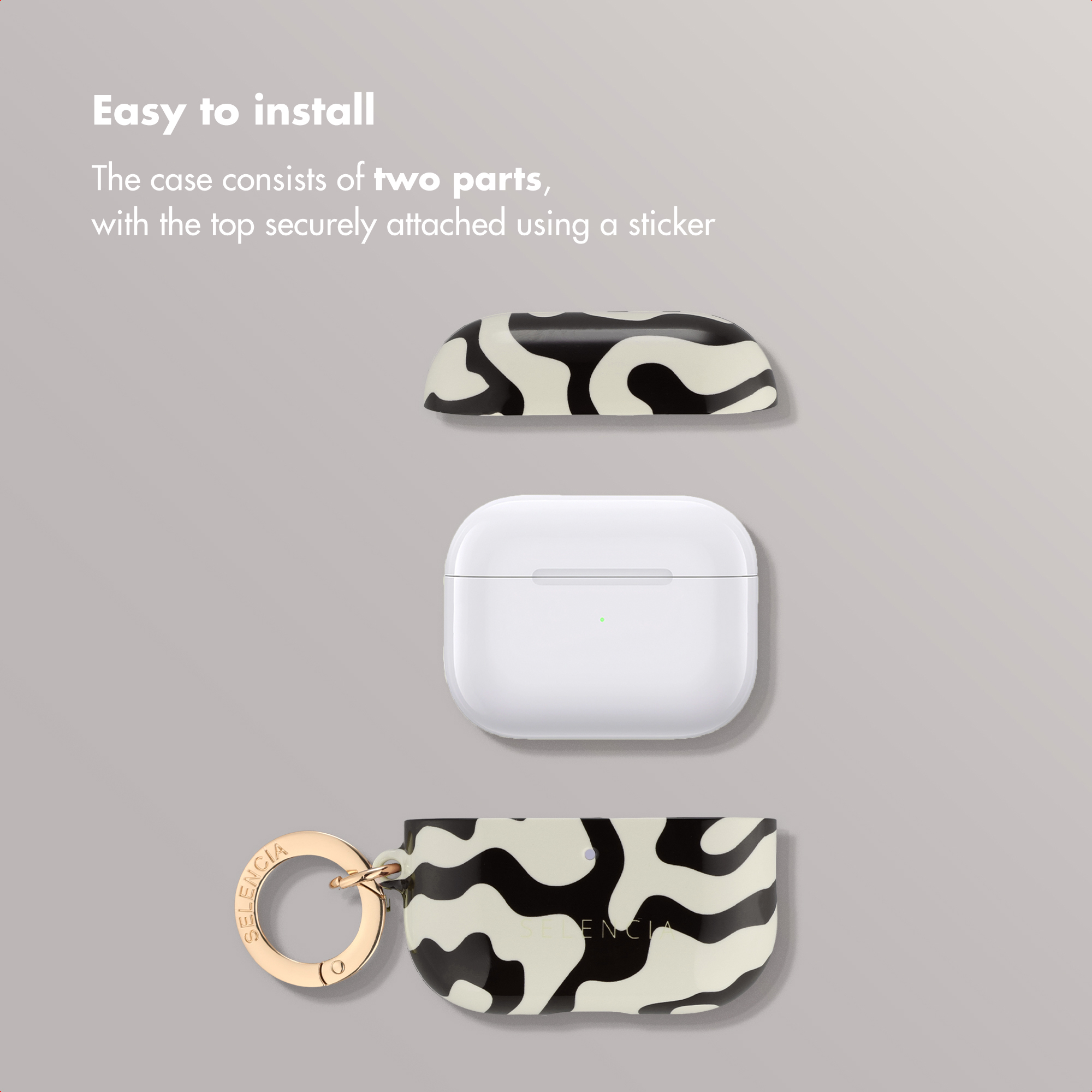 Una funda de AirPods desmontada en tres partes, con patrón abstracto en blanco y negro y llavero dorado.