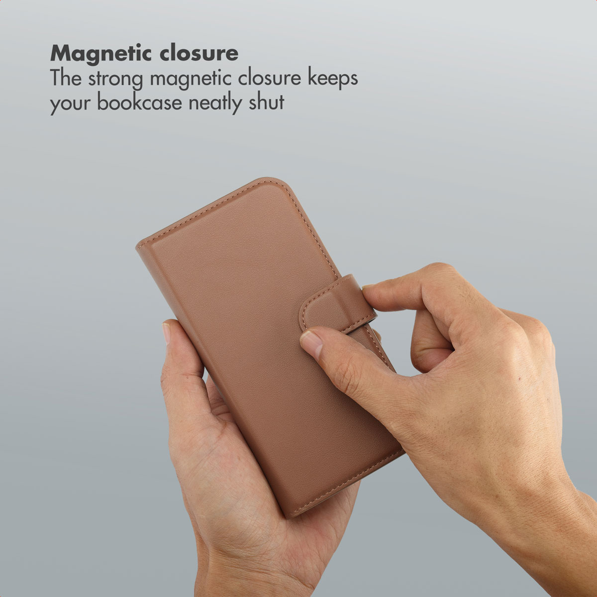 Un paio di mani apre o chiude una custodia per telefono marrone con chiusura magnetica.