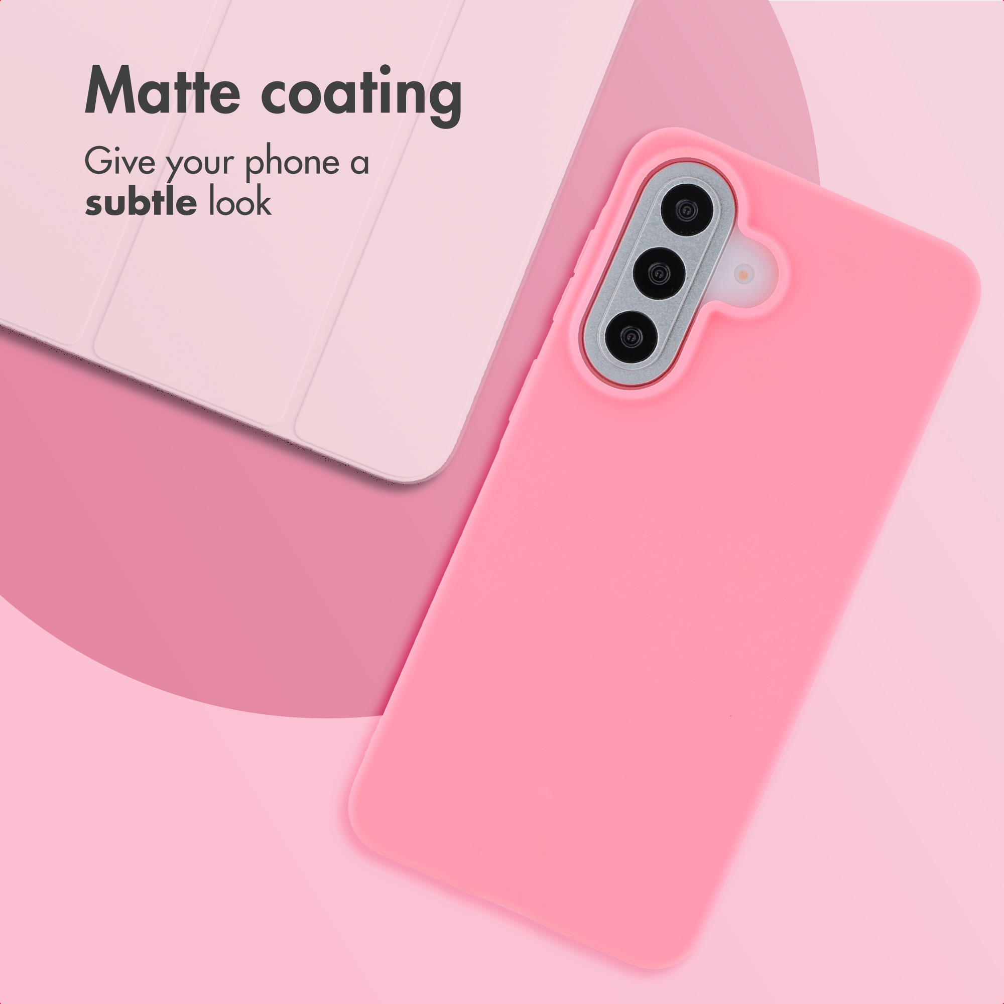 Un telefono rosa con custodia opaca si trova su una superficie rosa accanto a un tablet.