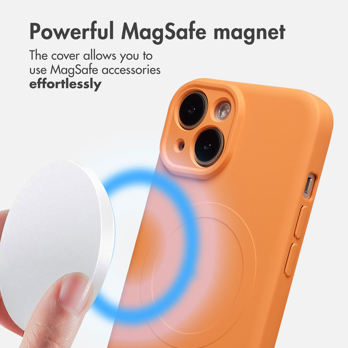 Ręka trzyma białe akcesorium MagSafe obok pomarańczowego etui na telefon.