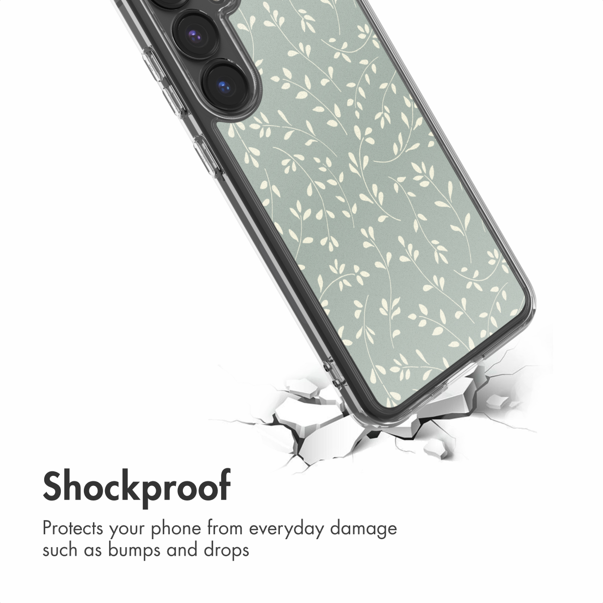 Un smartphone con funda verde salvia y hojas descansa sobre una superficie agrietada, texto Antigolpes.