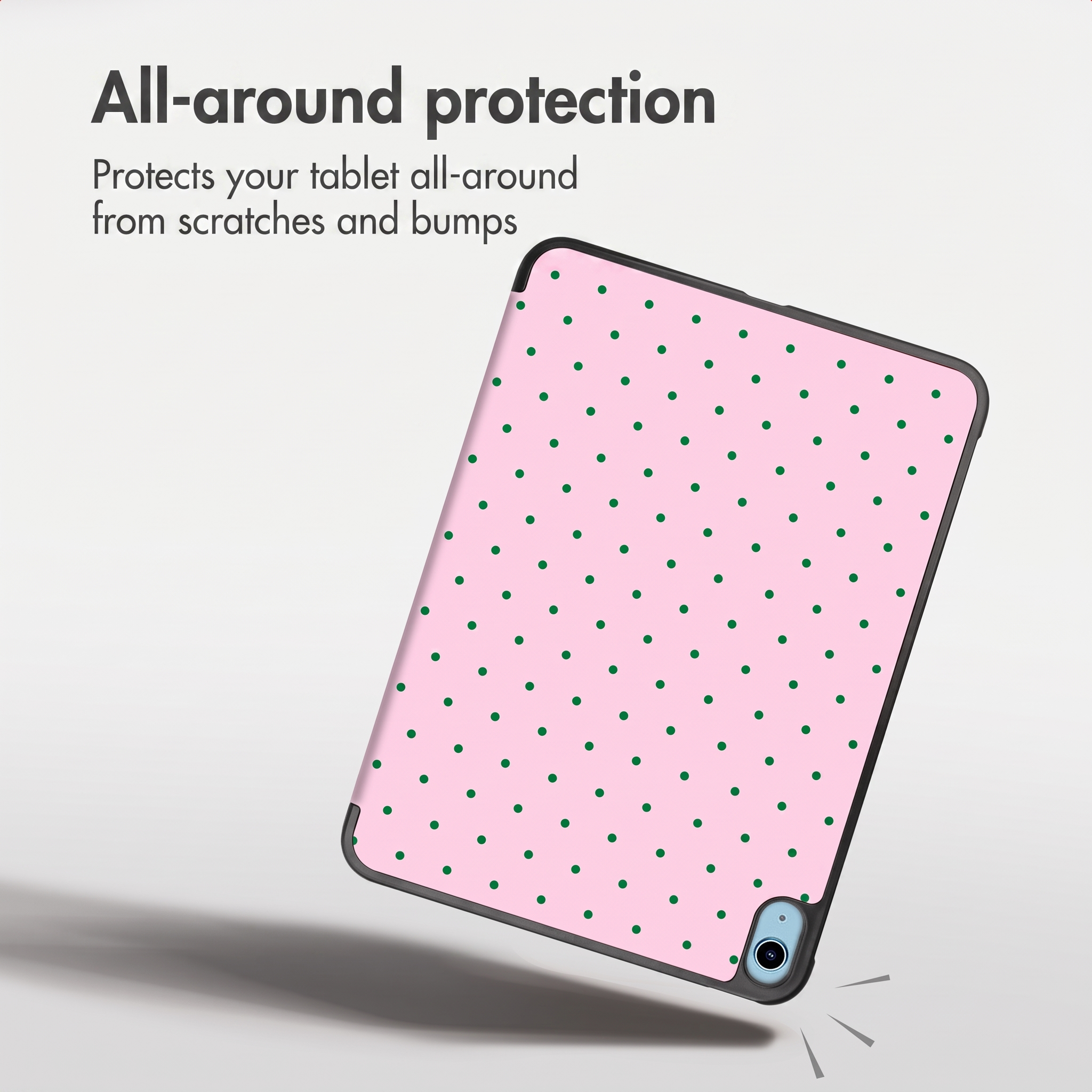 Een tablet in een roze hoes met groene stippen zweeft voor een witte achtergrond.