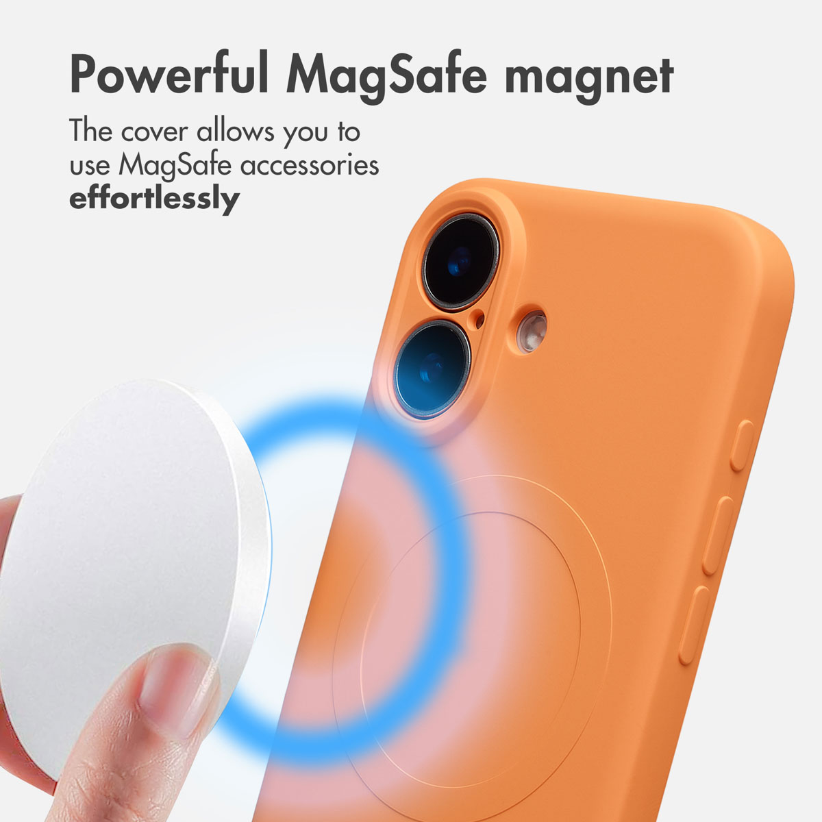 Una mano sostiene un imán redondo cerca de una funda de teléfono naranja con un anillo circular.