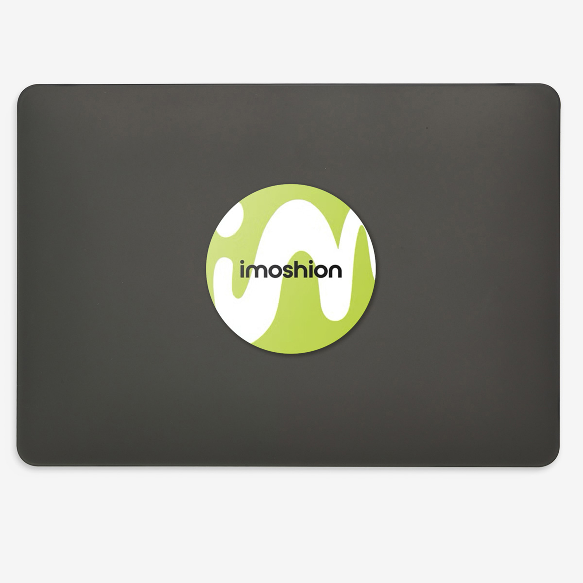 Tapa de portátil negra con una pegatina redonda verde y blanca con el logo de imoshion.