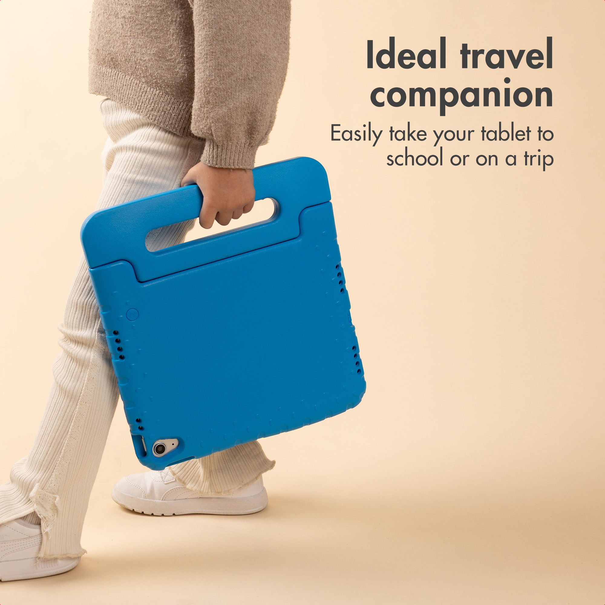 Un bambino in abiti beige trasporta una custodia blu per tablet su sfondo beige.