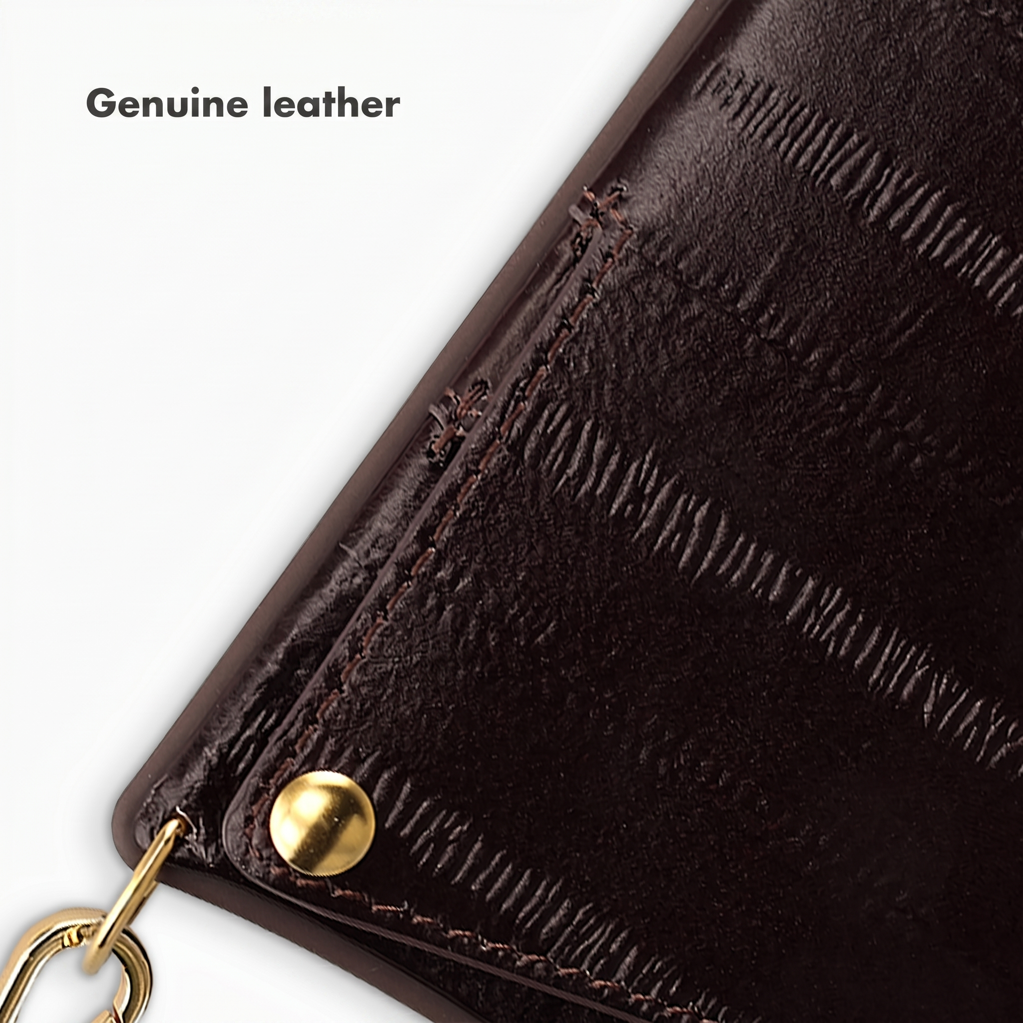 Gros plan de cuir véritable marron foncé avec coutures, clou doré et pièces métalliques sur fond blanc.