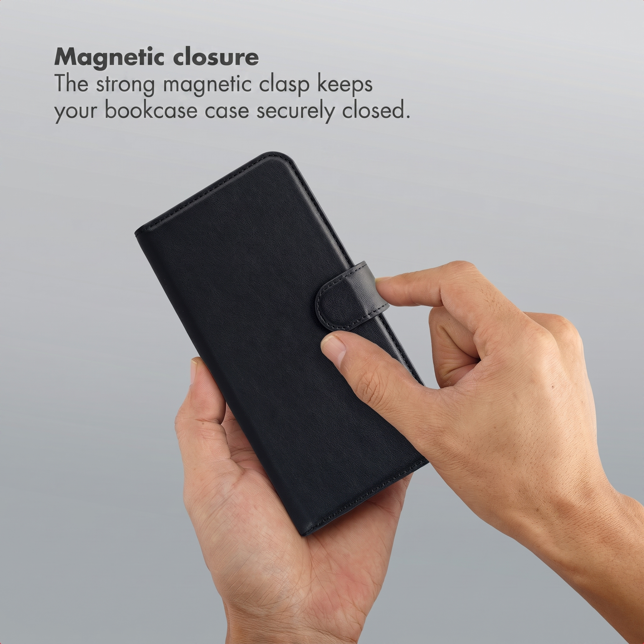 Hands holding a black leather phone case with magnetic closure.