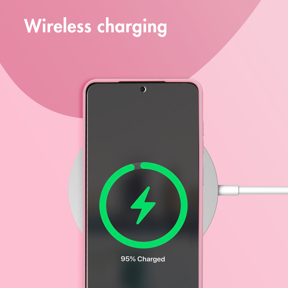 Un smartphone rosa en un cargador inalámbrico con icono de batería verde al 95%, sobre fondo rosa.